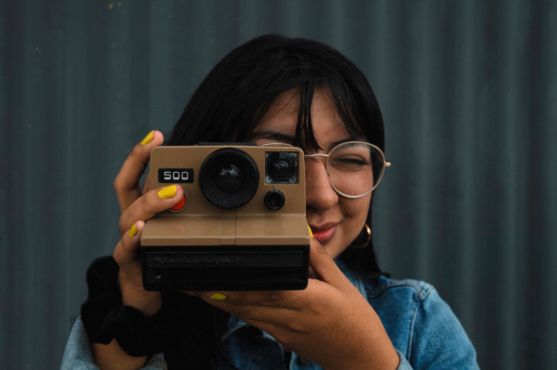 Female holding a polaroid camera.