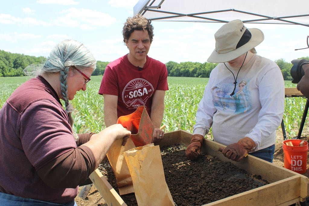 Laura J. Strunck, a senior anthropology major, and Anastasia Ervin, a graduate student in anthropology, sift through dirt at the Noble-Wieting archaeological site as Dr. Logan Miller looks on.
